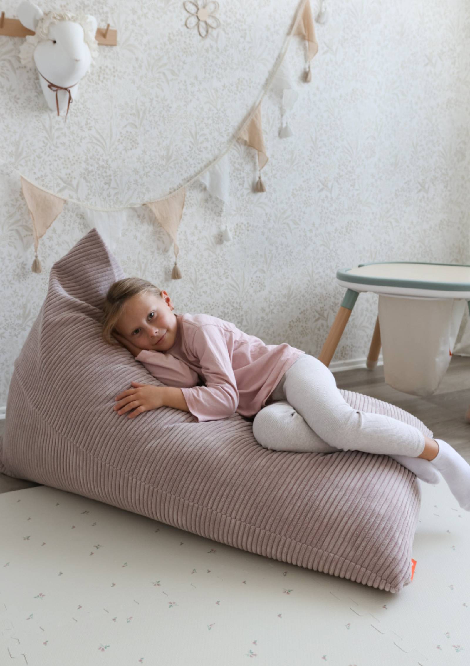 Mädchen liegt auf Funzy Lounger Sitzsack Cord Kirschblüte Rosa