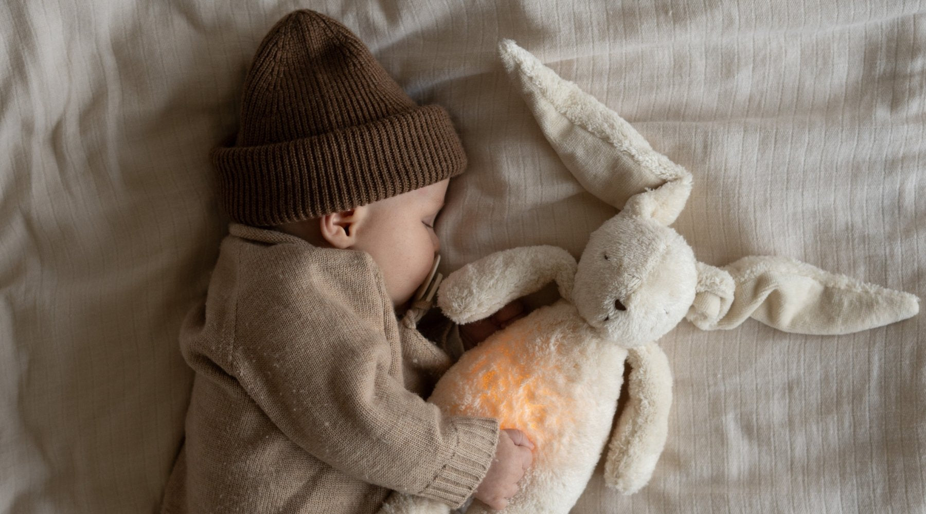 Gift Guide: Die schönsten Babygeschenke – im Bild: Moonie Einschlaf-Hase mit Licht 'Organic Humming Bunny 2.0' sand natur