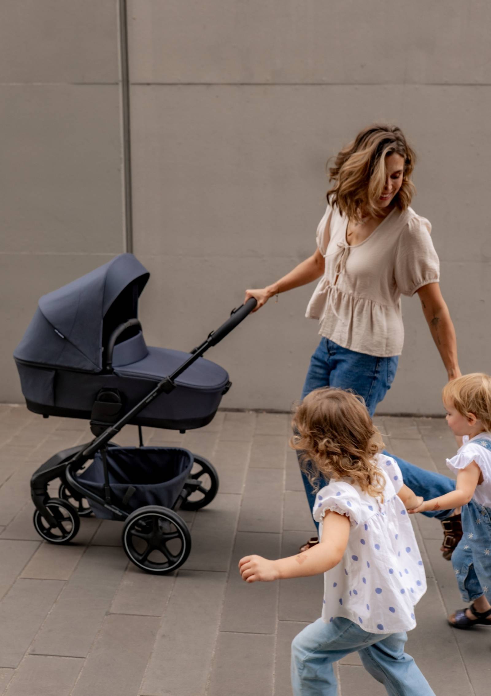 Frau unterwegs mit Kleinkind und Baby mit Easywalker Kinderwagen-Set 'Harvey NXT' Deep Blue inkl. Regenverdeck 