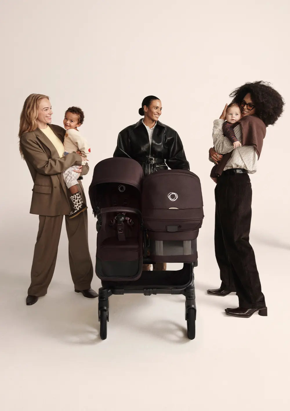 Frau schiebt Bugaboo Geschwisterwagen 'Donkey 6 Duo' Cocoa Brown in Begleitung anderer Frauen