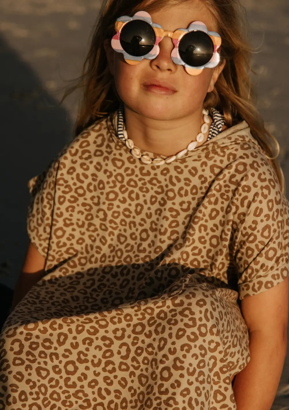 Mädchen trägt Cloby UV-Poncho UPF 50+ Leopard Brown