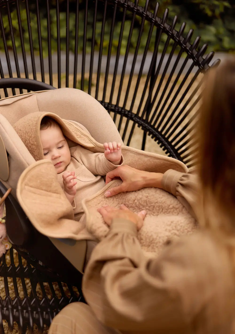 Baby liegt in Babyschale mit der Jollein Merino Einschlagdecke für Babyschale 'Sherpa' Natural