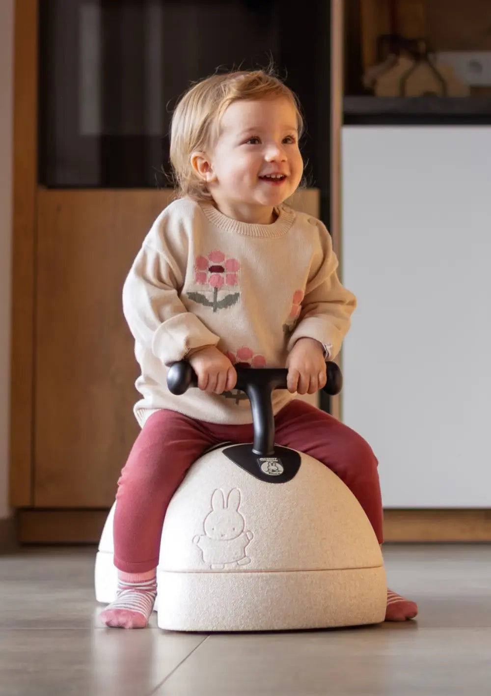 Kleines Mädchen rutscht mit dem Scoot and Ride 3-in-1 Babyroller 'My First' miffy